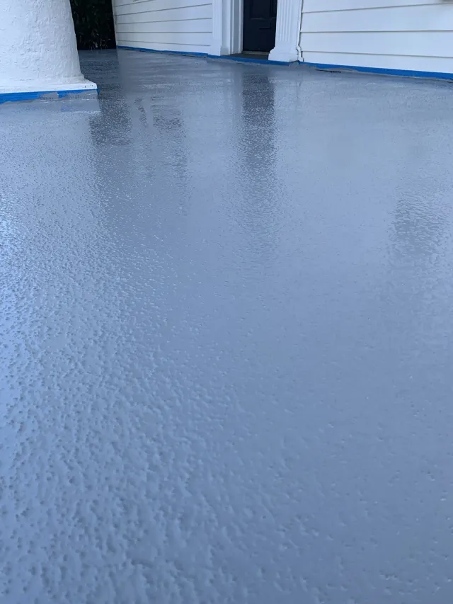 Blue-painted concrete floor between white walls, with a wet, textured surface and reflections at the top.