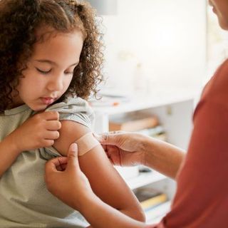 A little girl is getting an injection in her arm.