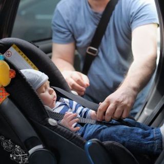 A baby sleeping in a car seat.