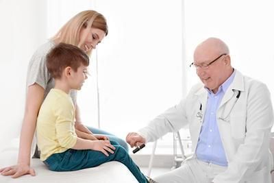 A doctor is talking to a little boy and his mother.