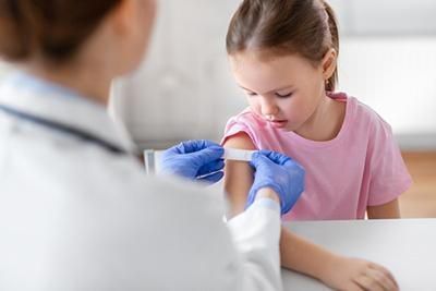 A little girl is getting a vaccine from a doctor.