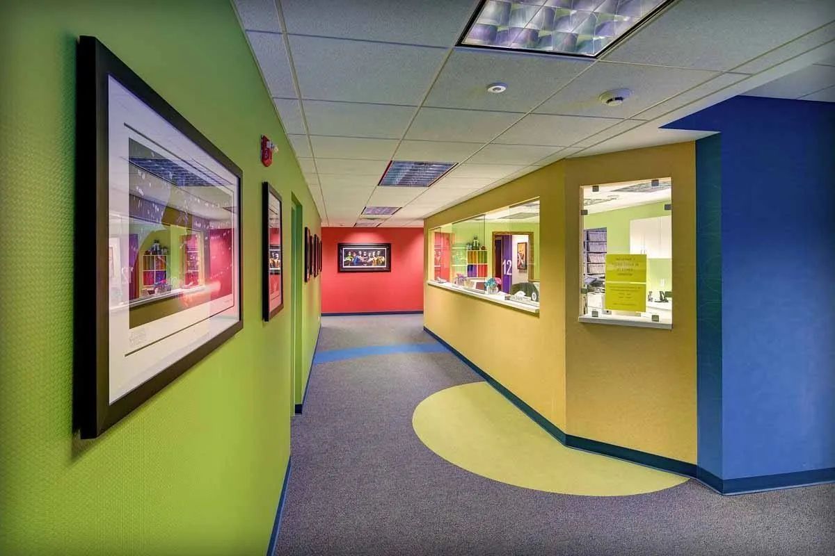 A long hallway with colorful walls and carpeted floors