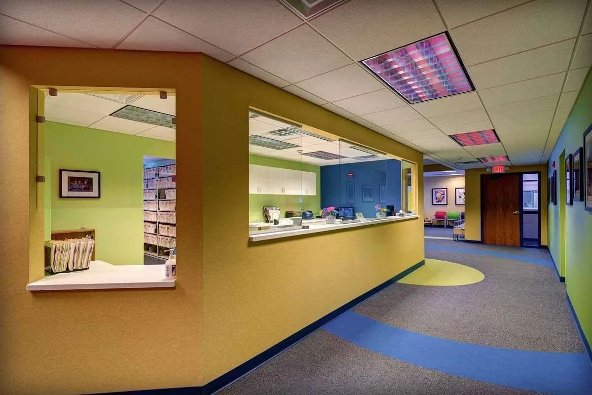 A hallway with a reception desk in the middle of it