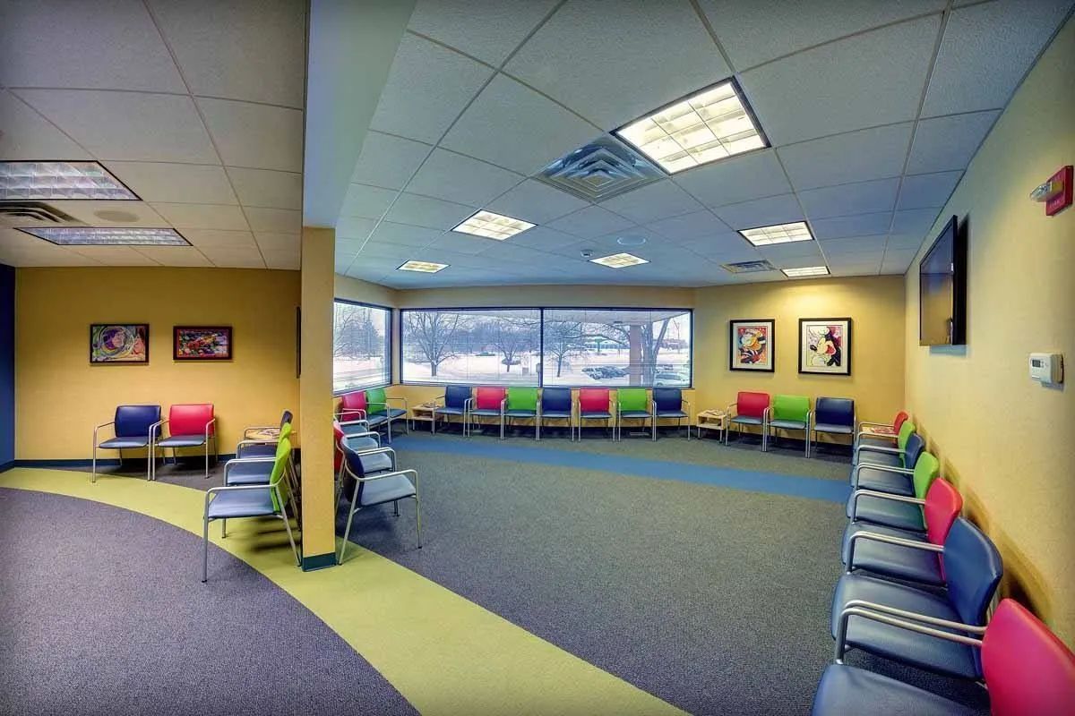 A waiting room with a lot of colorful chairs