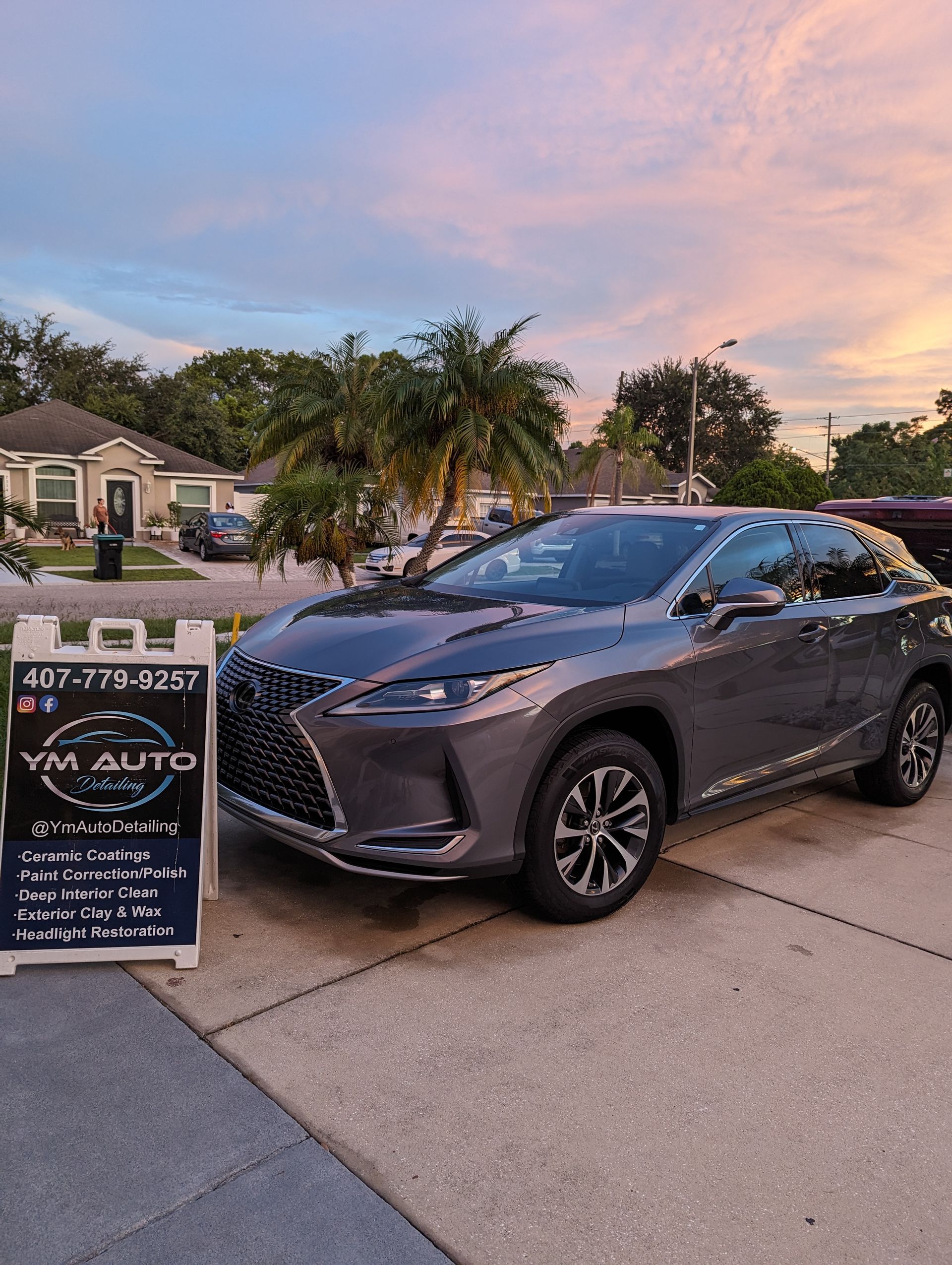 a gray lexus rx 350 is parked in a driveway next to a sign .
