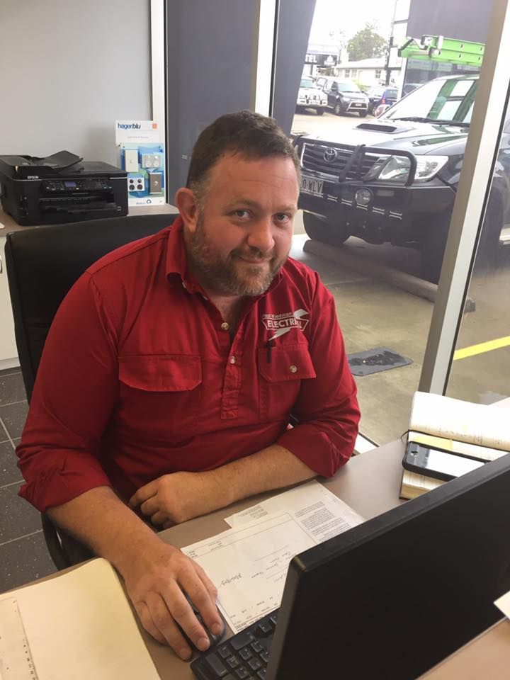A Man with Computer and Car in The Background — Paul Wiedman Electrical in Harristown, QLD