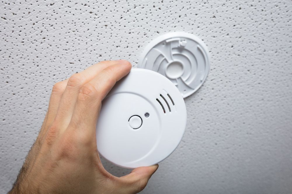 A White Smoke Detector on A Textured White Ceiling — Paul Wiedman Electrical in Harristown, QLD