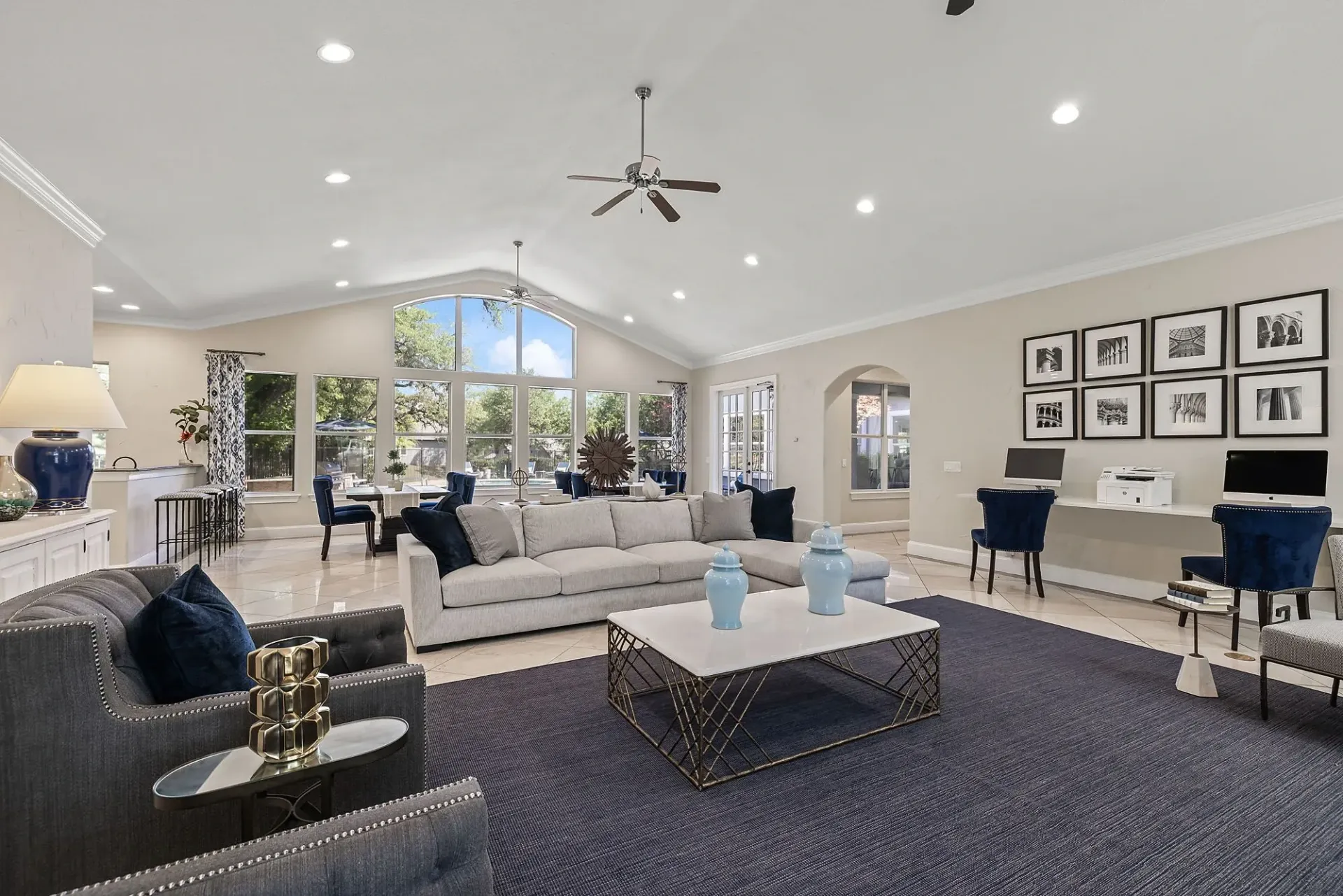 Spacious community lounge area with seating, computers, and large windows overlooking the outdoors.
