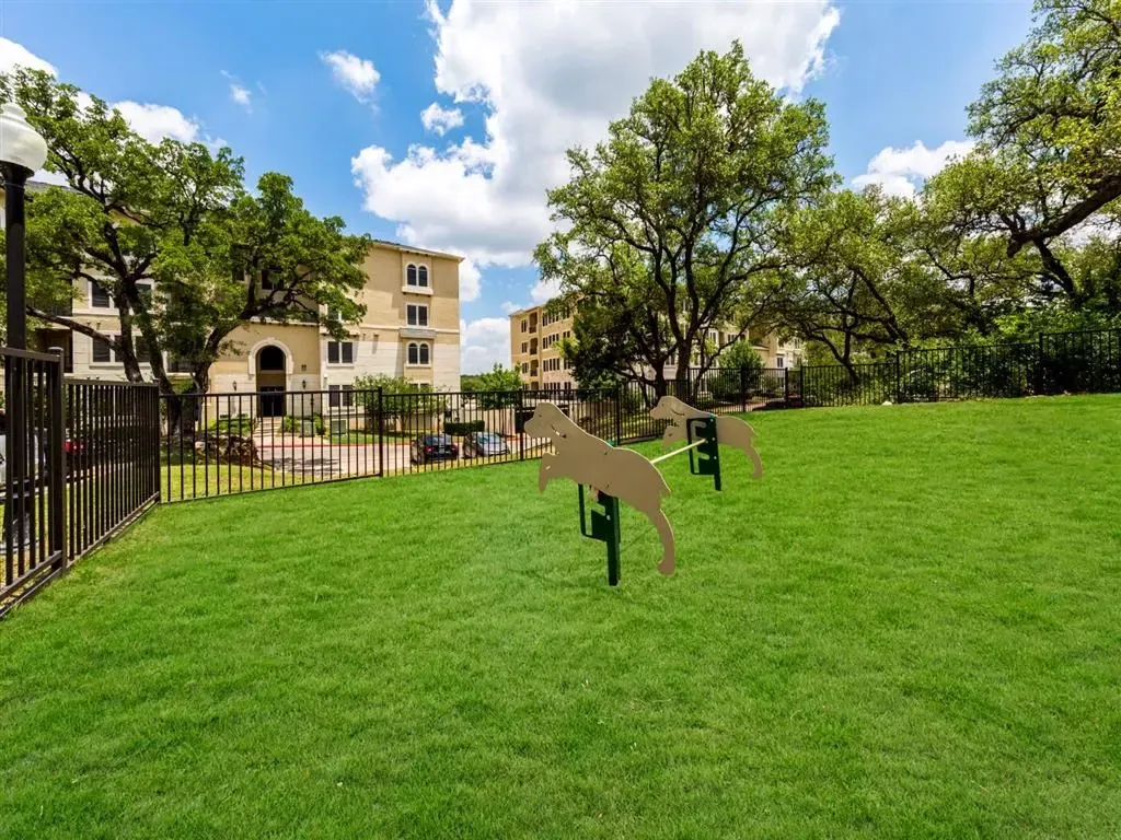 Dog park area with grassy lawn and playful dog-shaped structures.
