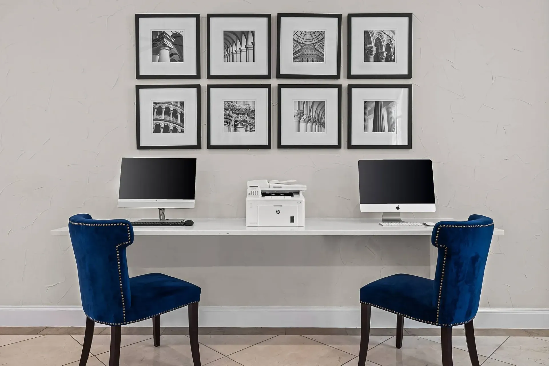 Business center with computers and printer, featuring artwork.