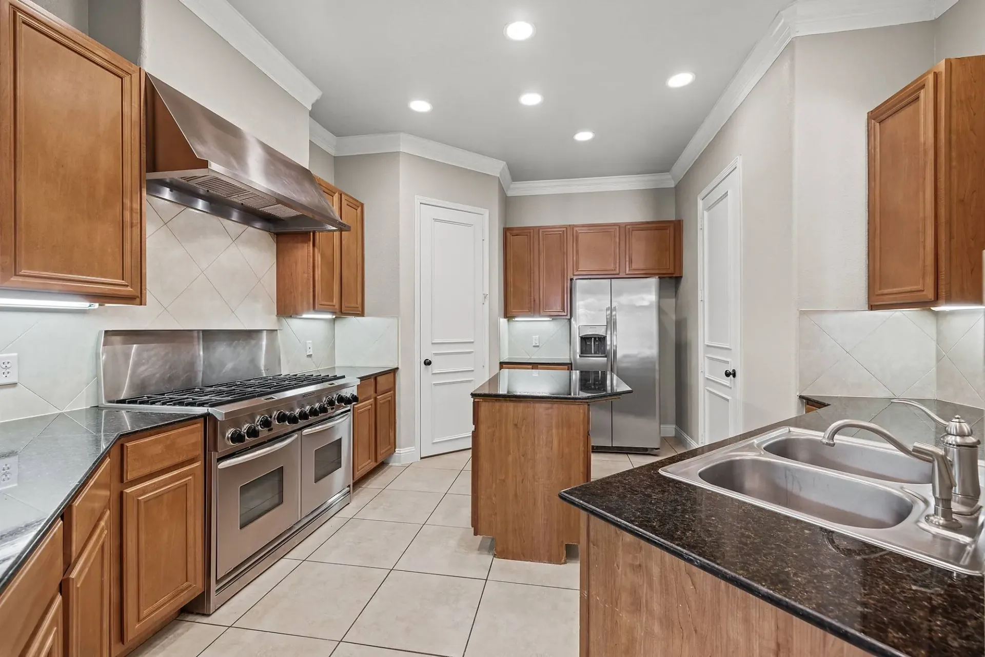 Spacious kitchen with stainless steel appliances, granite countertops, and custom cabinetry.