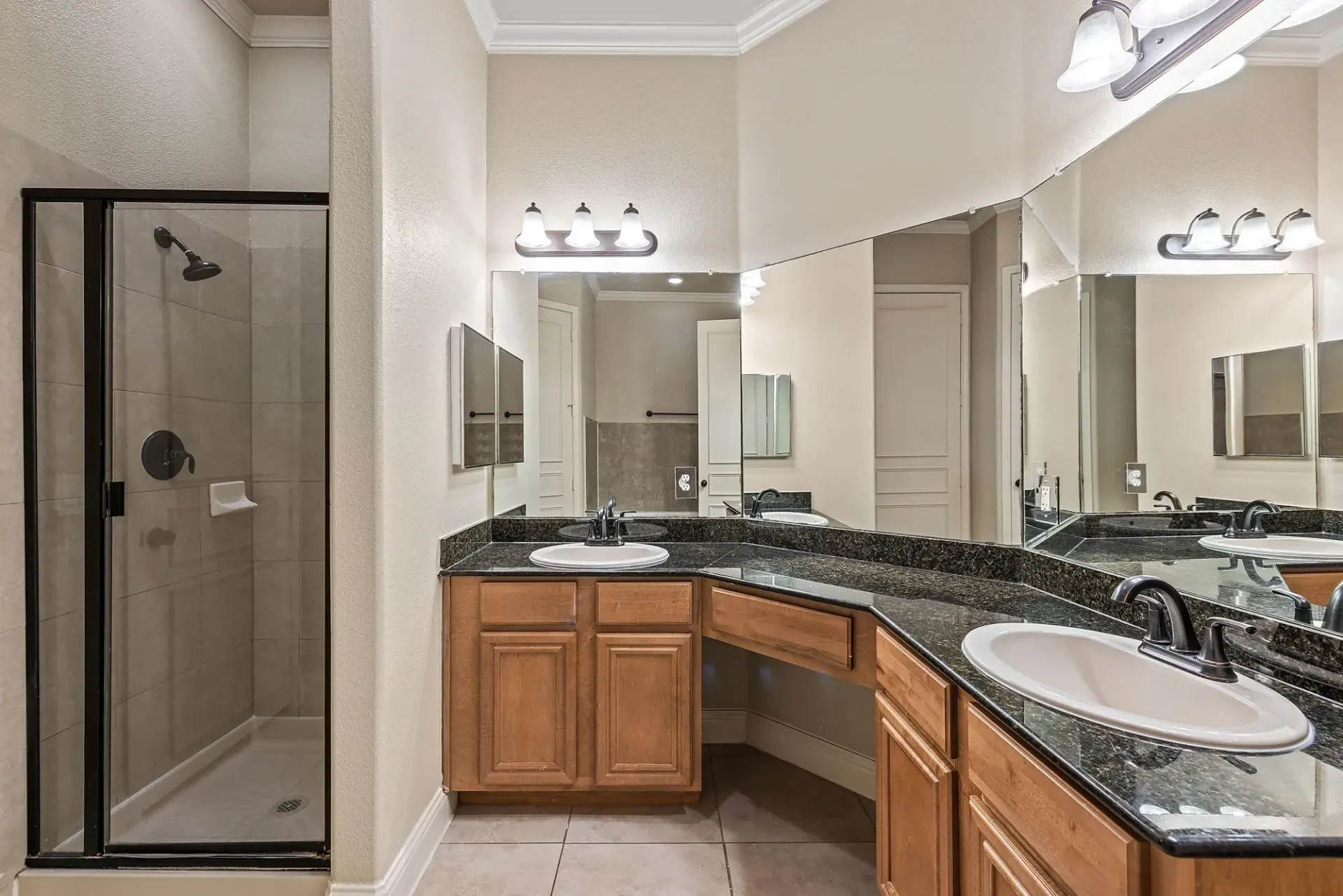 Bathroom vanity with double sinks and a walk-in shower.