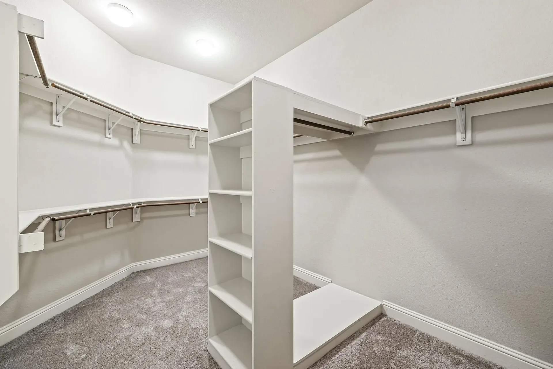 Spacious walk-in closet with built-in shelving and ample hanging space.