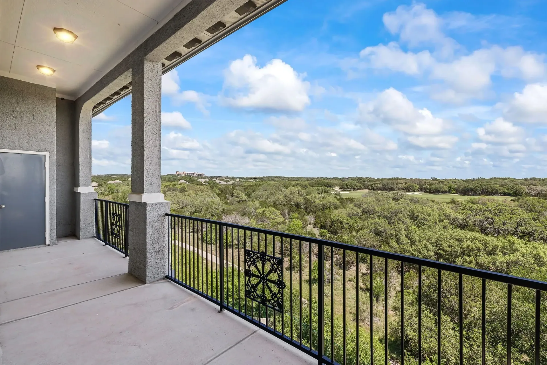 Balcony with view of trees and golf course