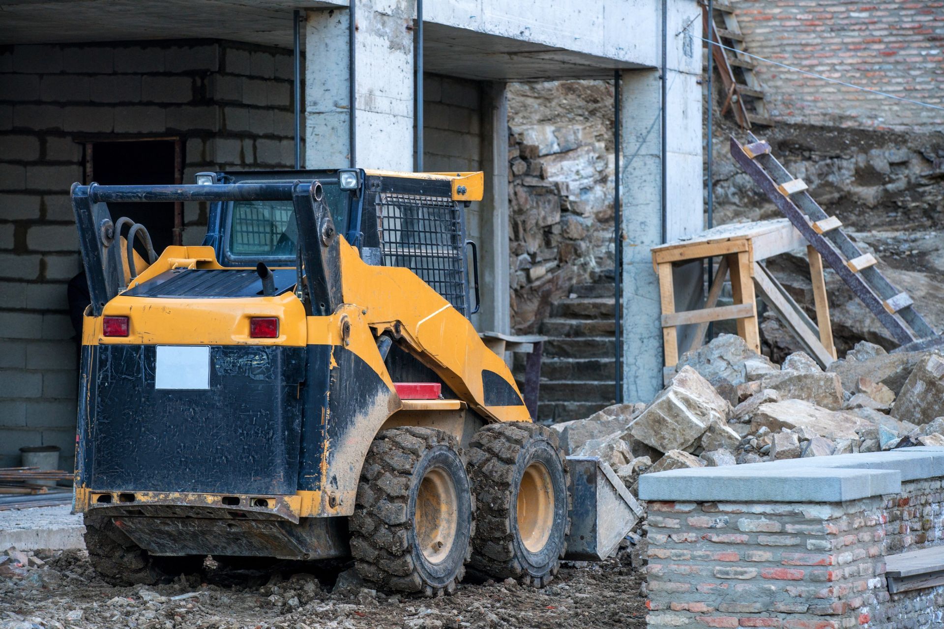 A bulldozer is parked in front of a building under construction.