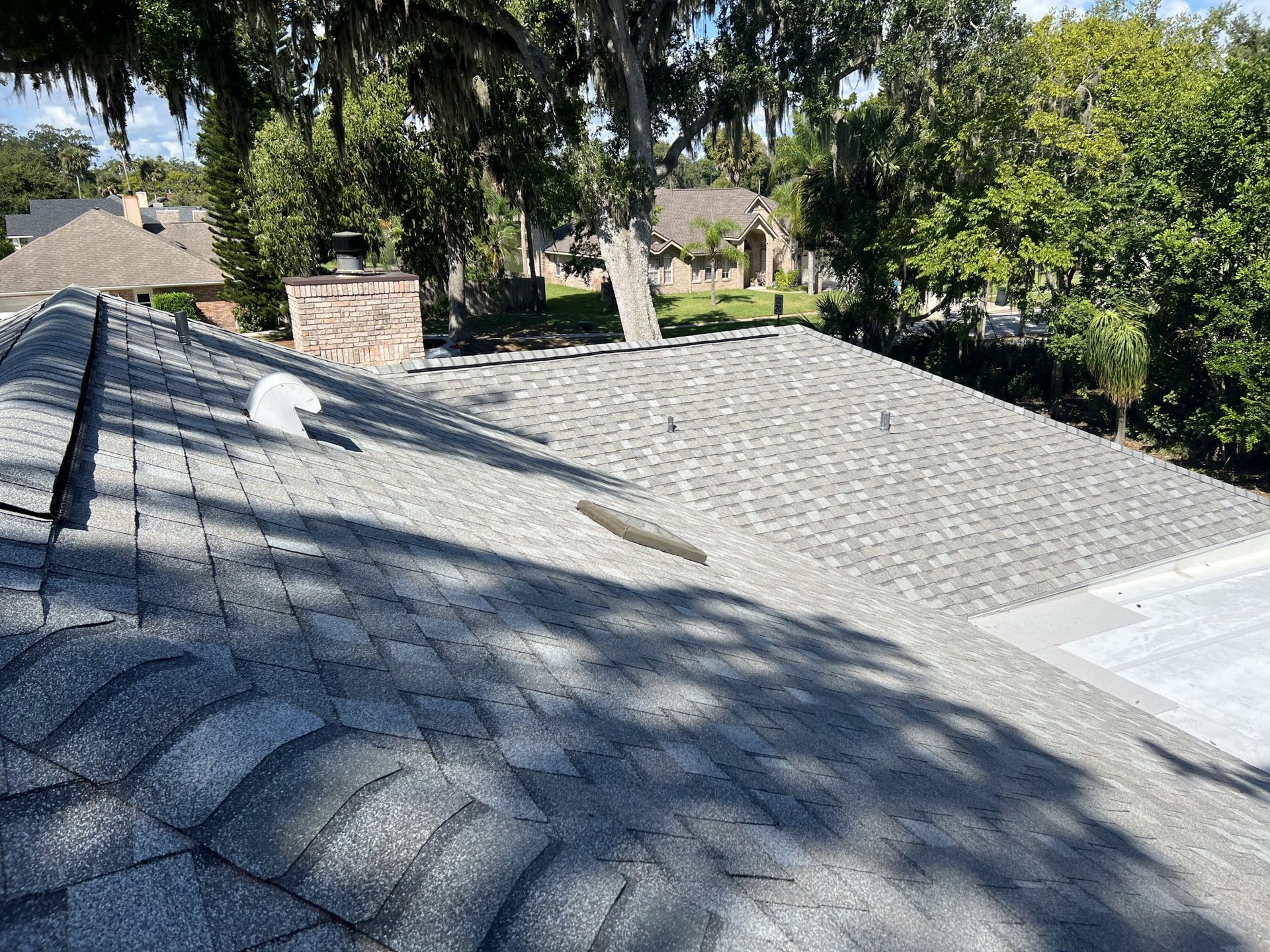 Roofing worker lifting shingles on a damaged roof during repair work