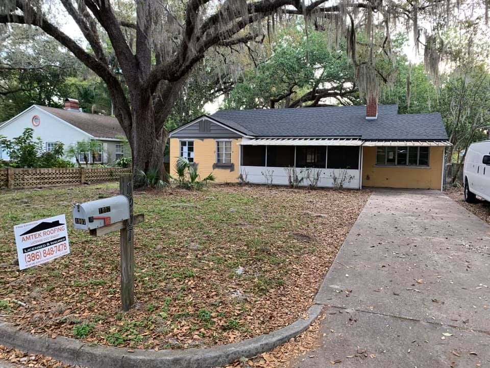 Single-story tan house with large tree, driveway, and mailboxes in the front yard.