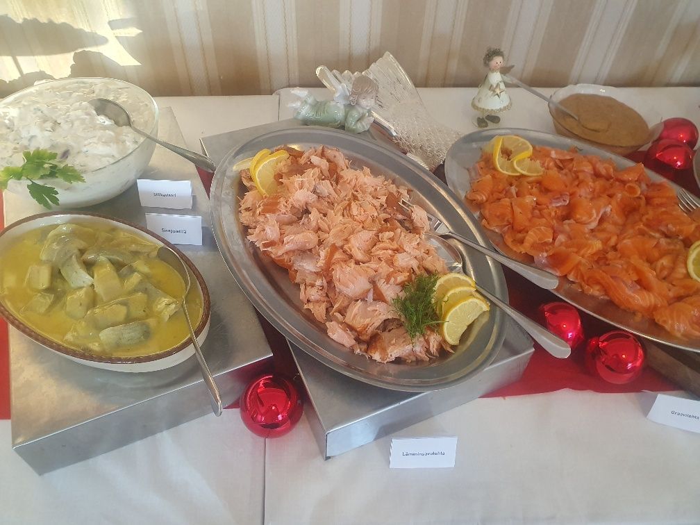 A buffet table with plates of food including smoked salmon