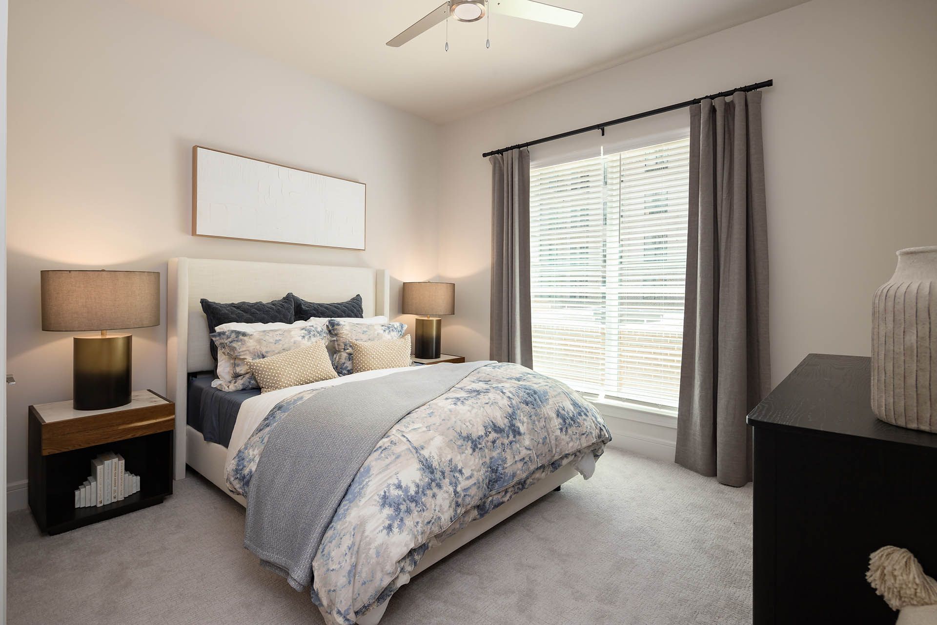 A bedroom with a large bed and a ceiling fan.
