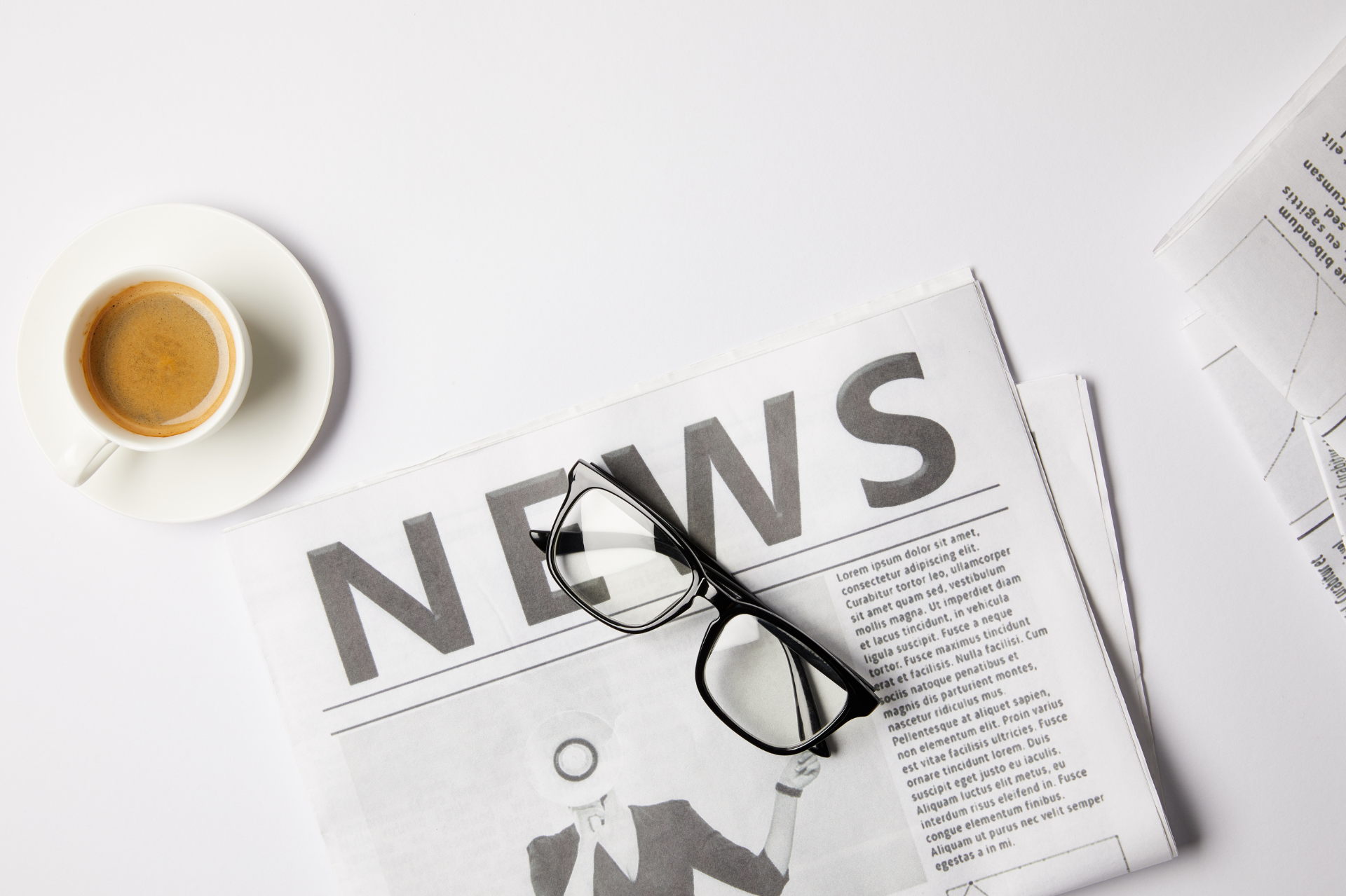Un periódico con la palabra noticias escrita junto a un par de vasos y una taza de café.