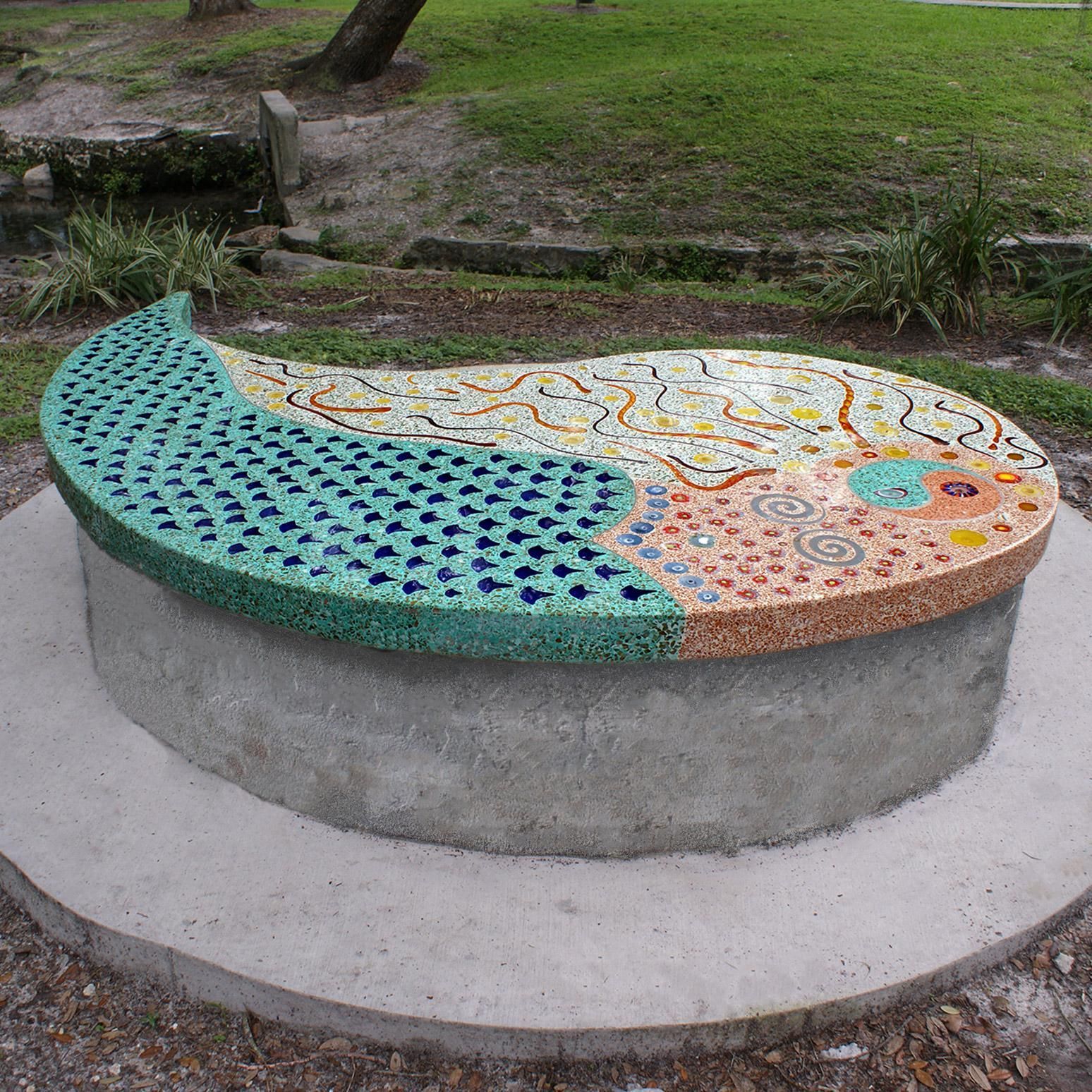 A concrete bench with a peacock design on it