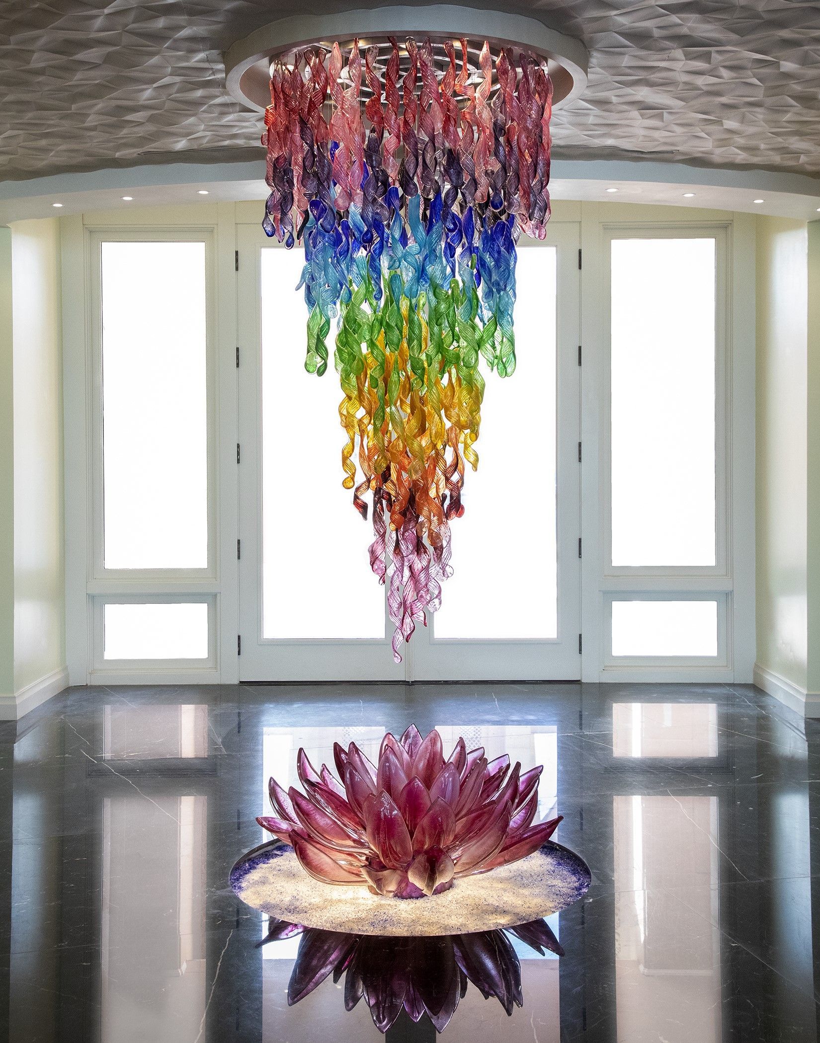 A room with a chandelier and a flower in the middle