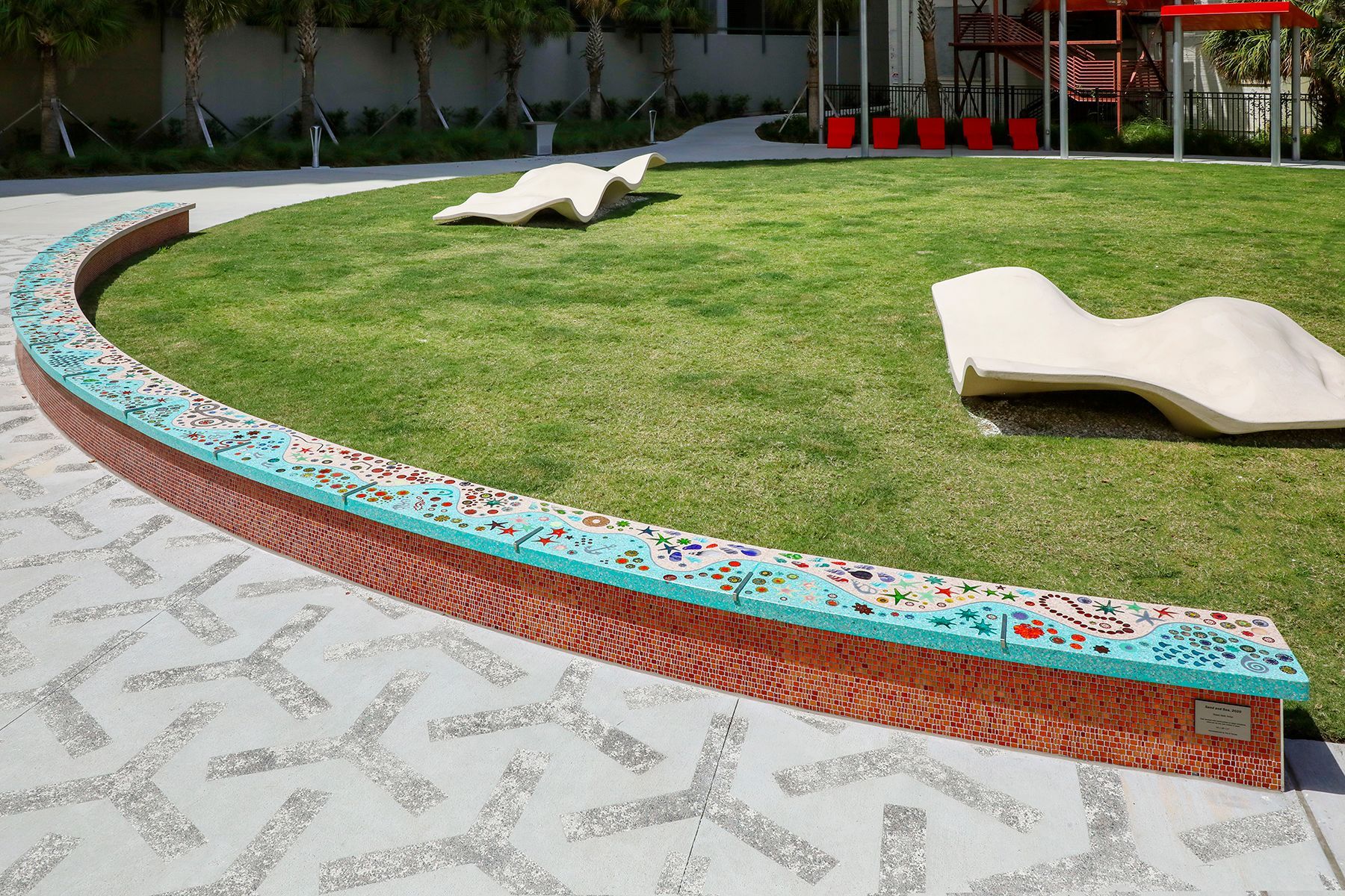 A lawn with a concrete curb and a few chairs on it