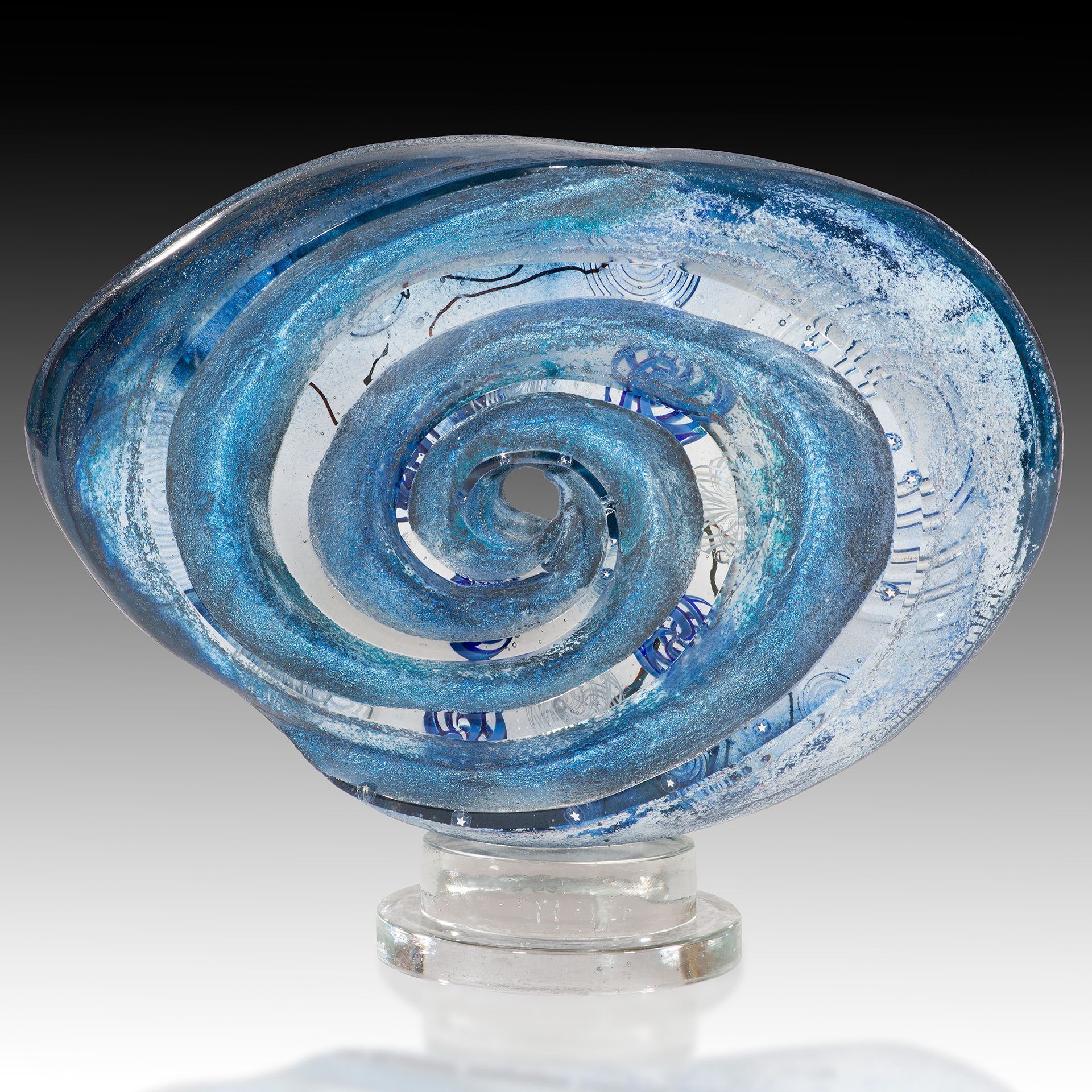 A blue glass sculpture with a spiral design on it