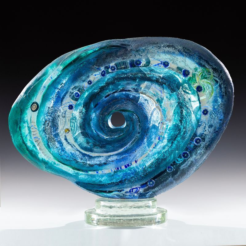 A blue glass sculpture of a spiral with a hole in the middle