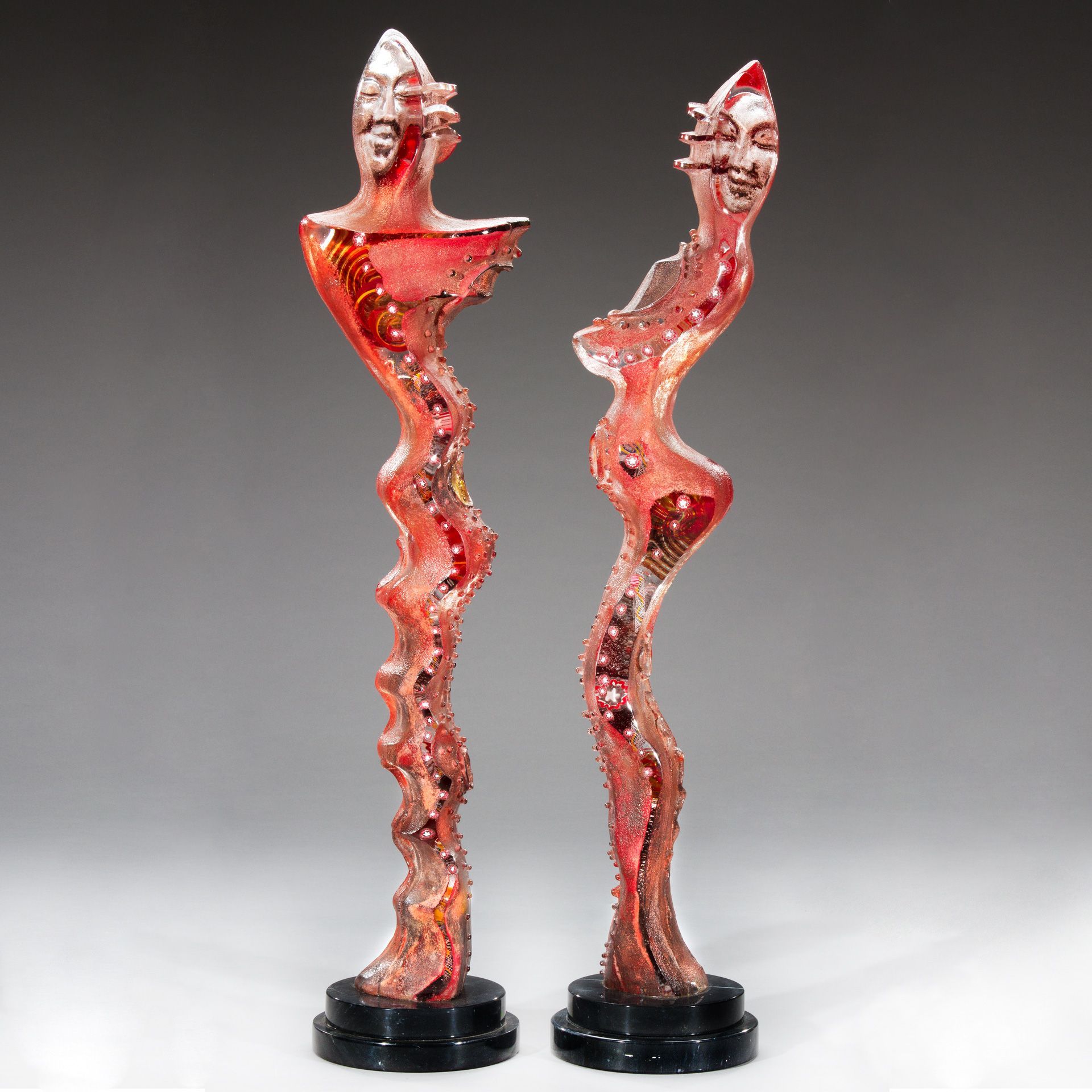 Two red sculptures with faces on them are sitting next to each other