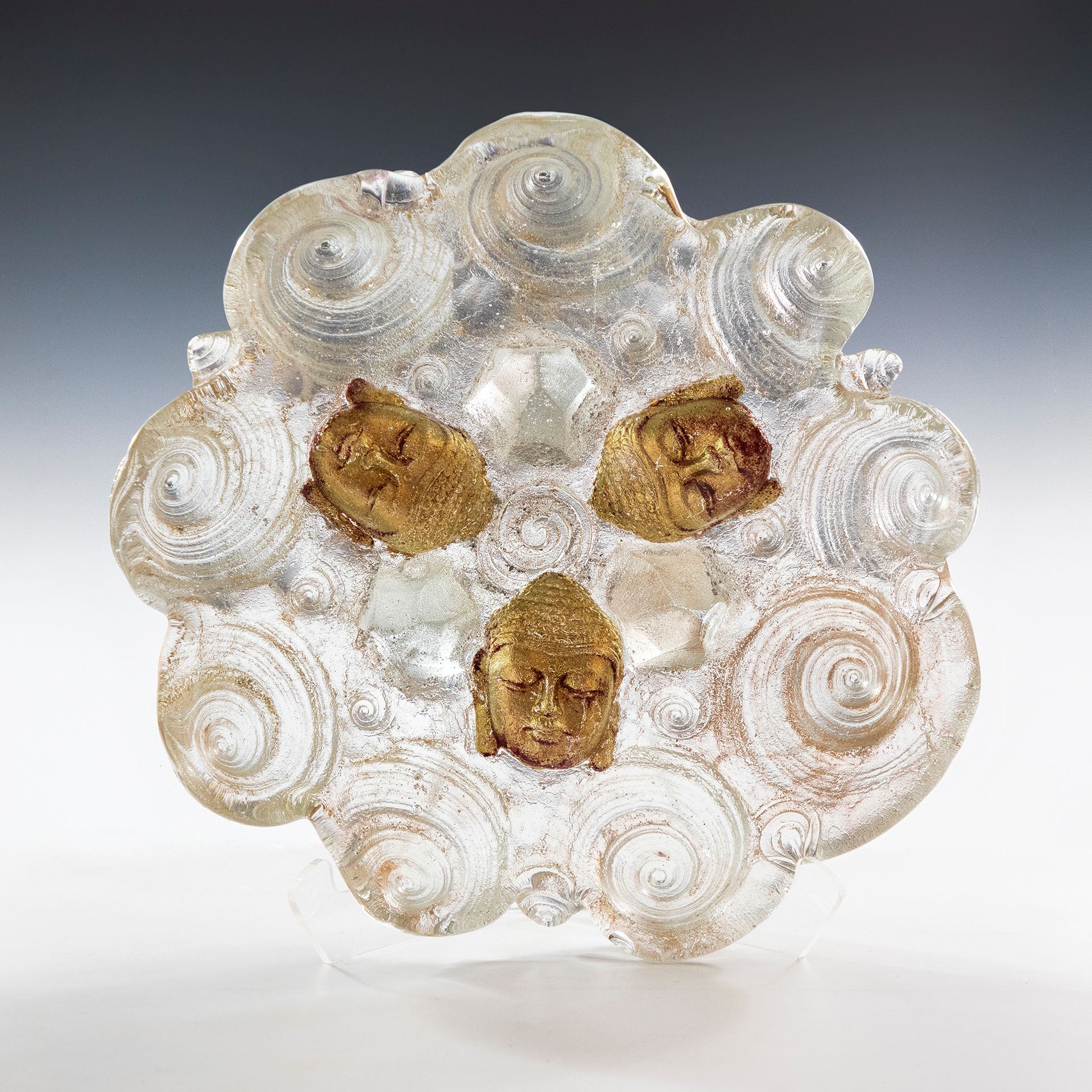 A clear glass object with gold faces on it