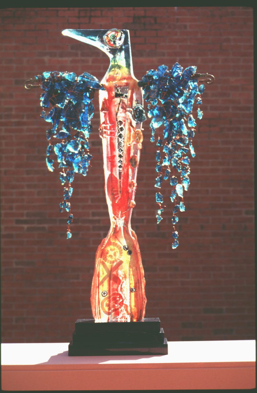 A statue of a bird with blue wings is sitting on a table