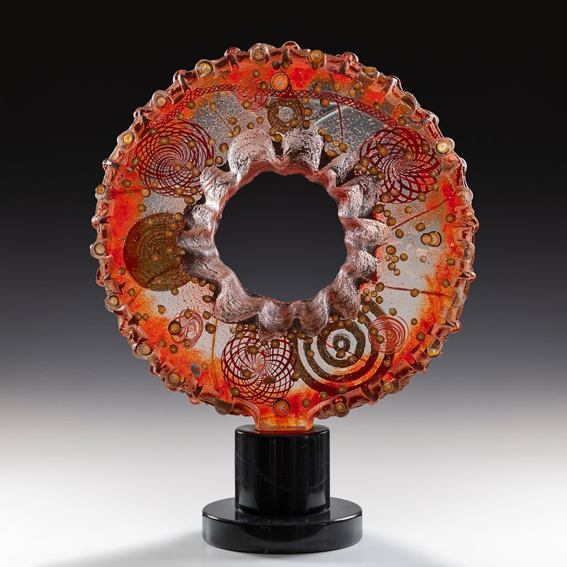 A glass sculpture with a hole in the middle of it