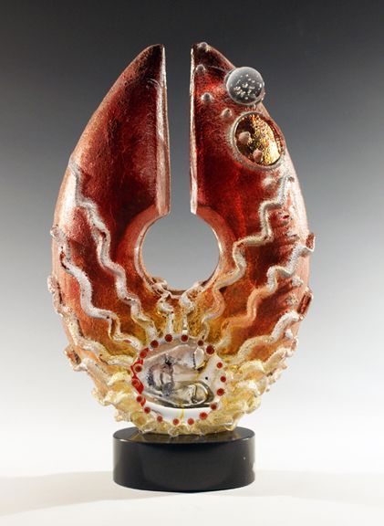 A red and gold sculpture with a hole in the middle