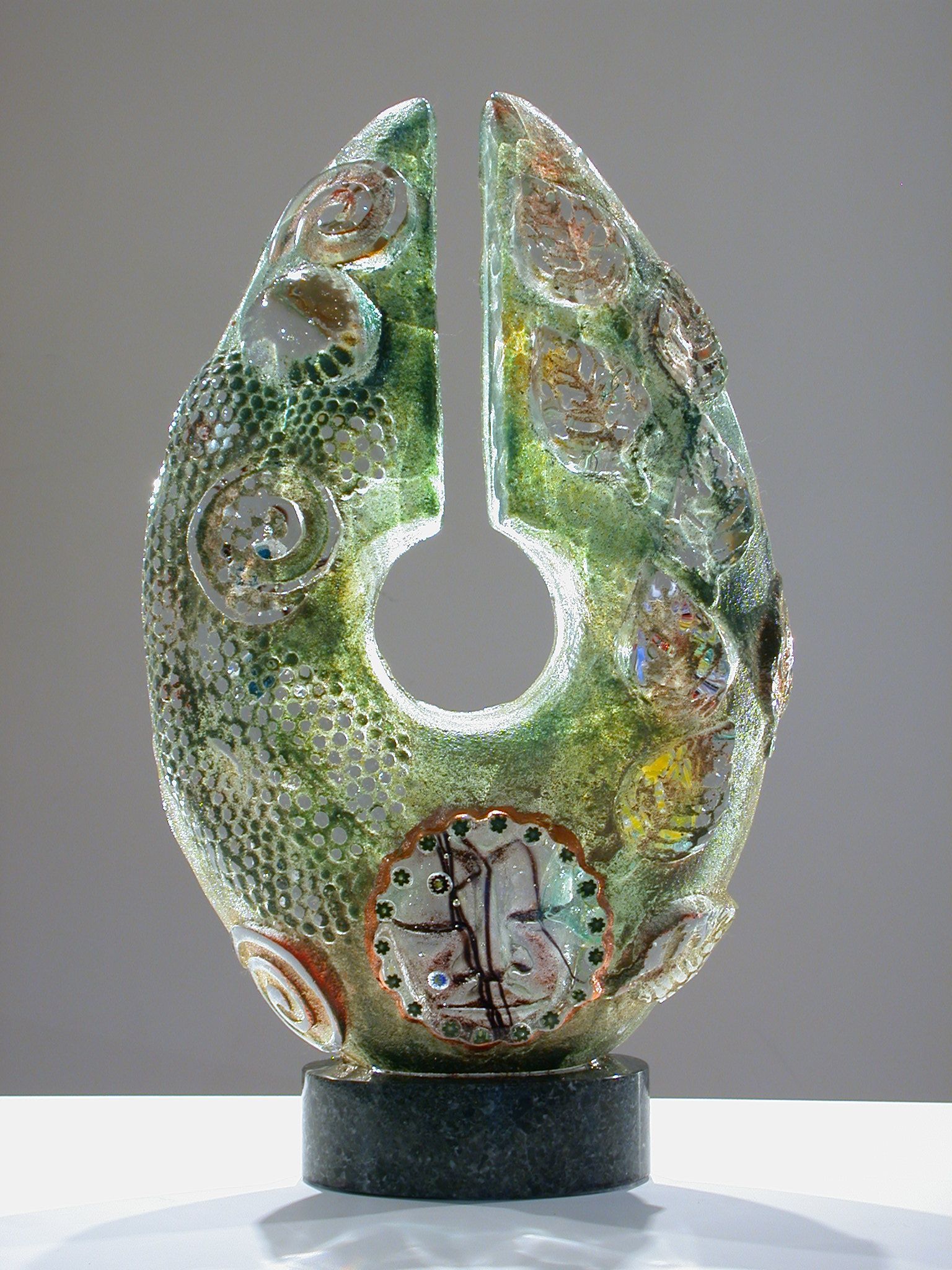 A green sculpture with a hole in the middle is sitting on a table.
