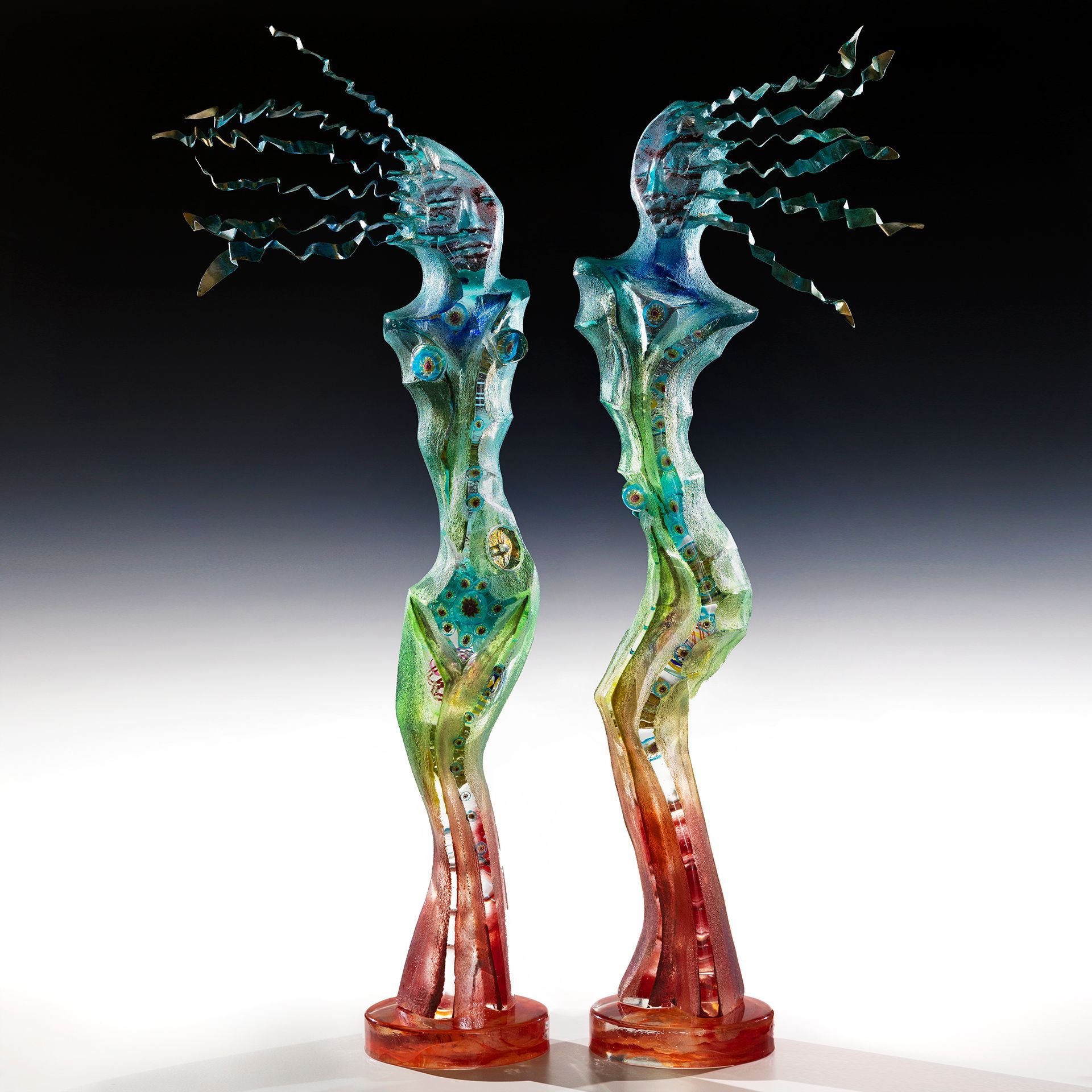 Two sculptures of a woman with wings are standing next to each other