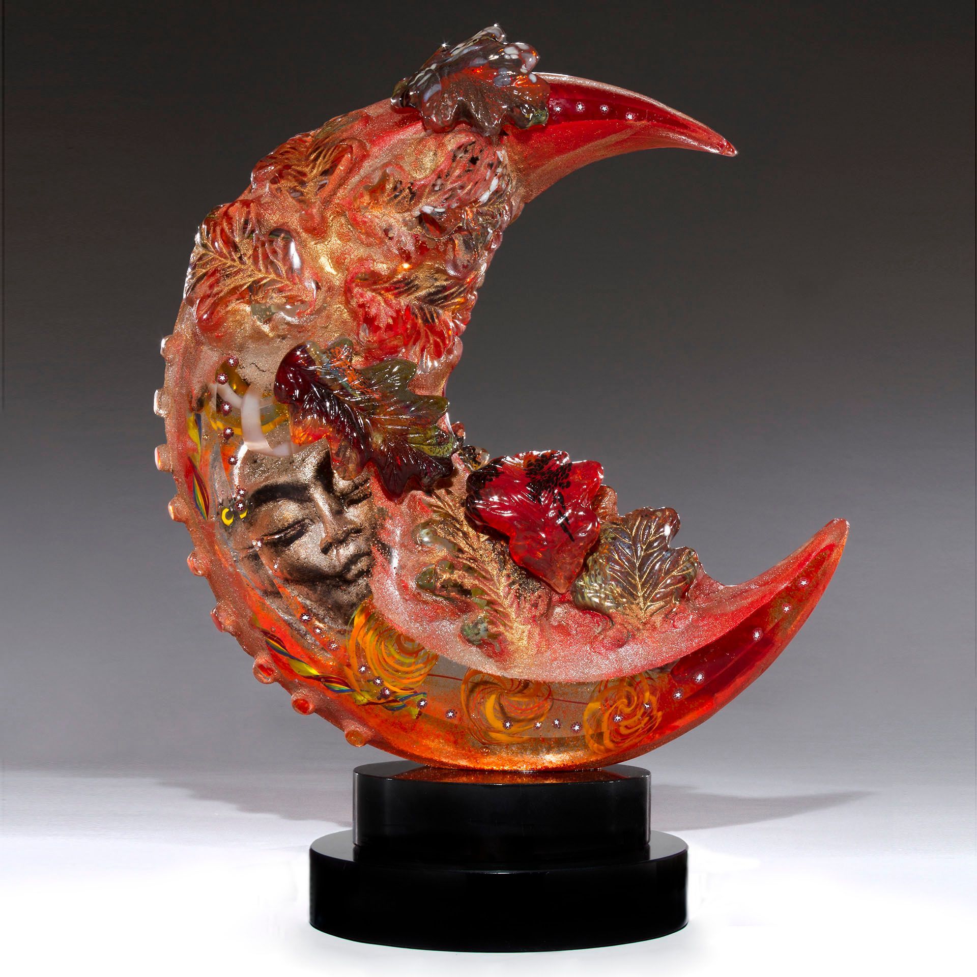 A sculpture of a crescent moon with a face on it