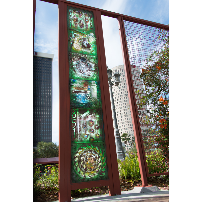 A fence with a painting on it and a building in the background
