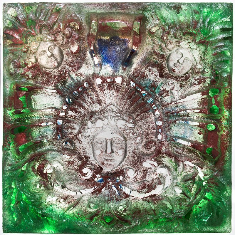A green and brown painting with a face in the middle.