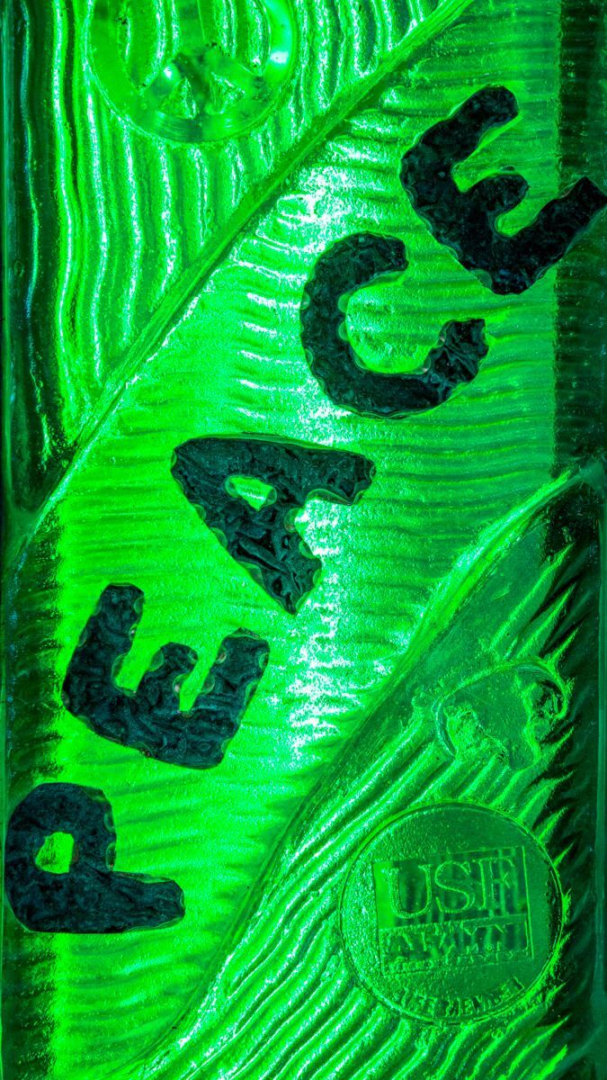 A green leaf with the word peace written on it.