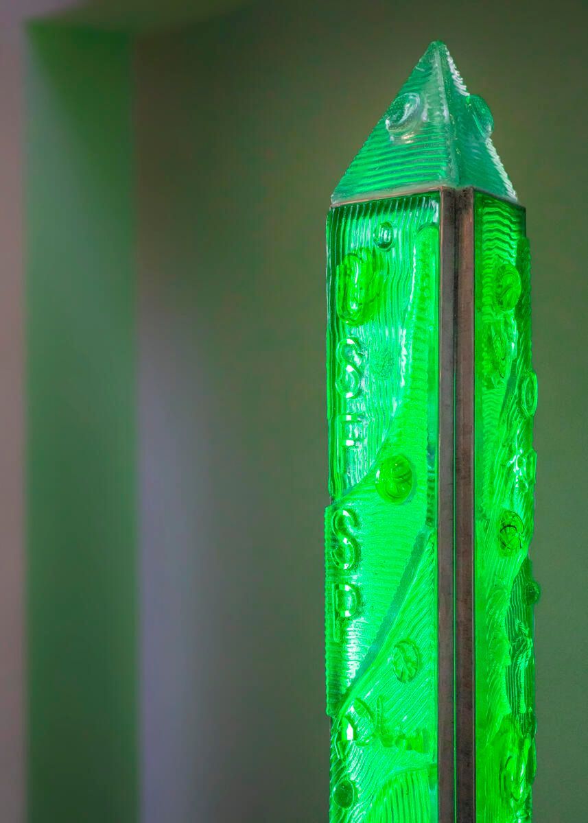 A close up of a green crystal on a table.