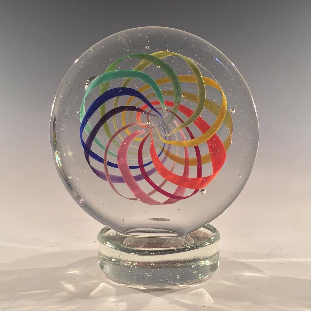 A clear glass ball with a rainbow design on it