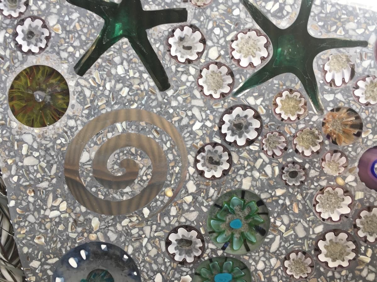 A mosaic of flowers and stars on a gray surface