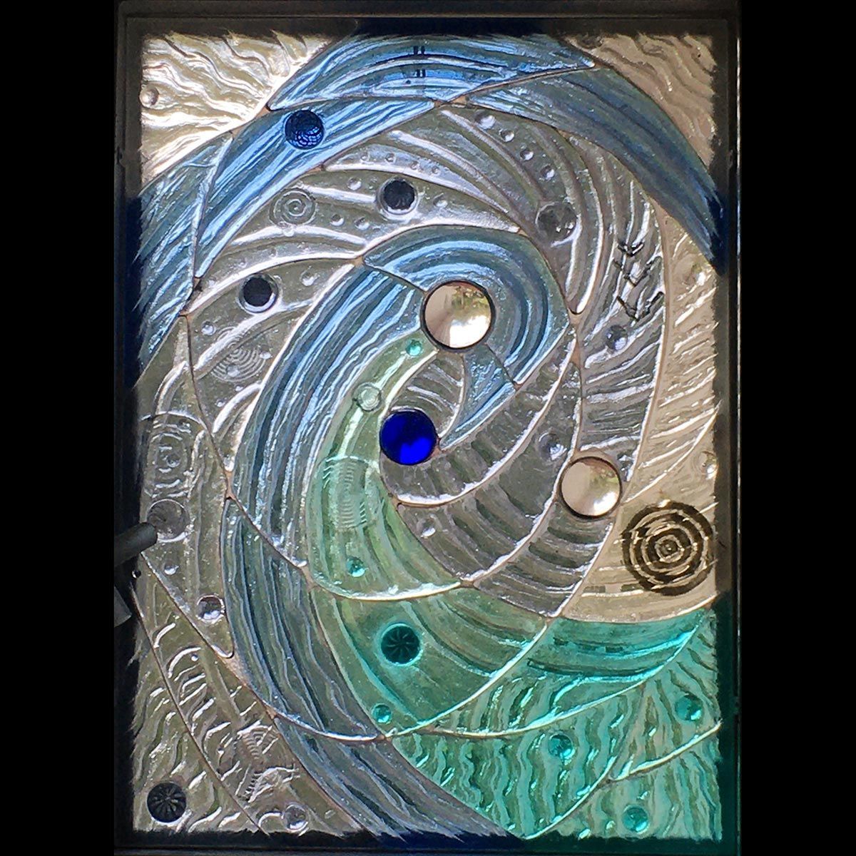 A stained glass window with a swirl and circles on it.