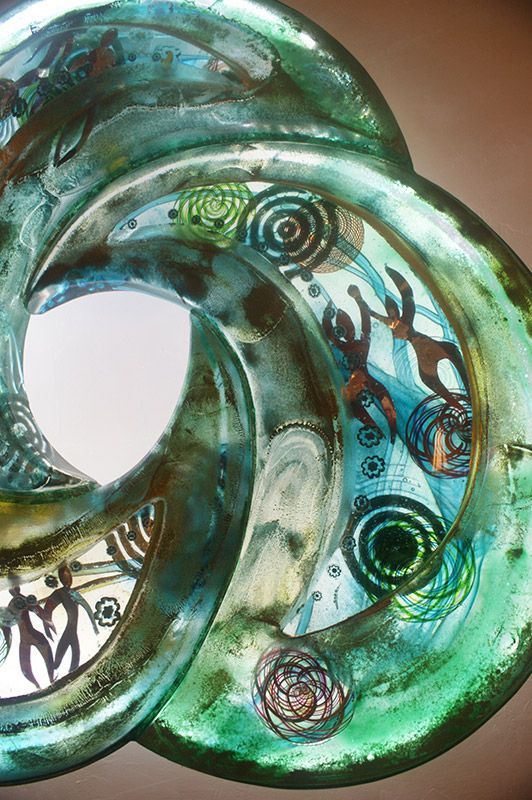 A close up of a glass sculpture with a swirl design on it.