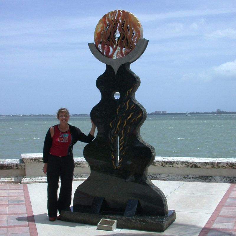 A woman stands in front of a statue that says ' u.s.a. ' on it
