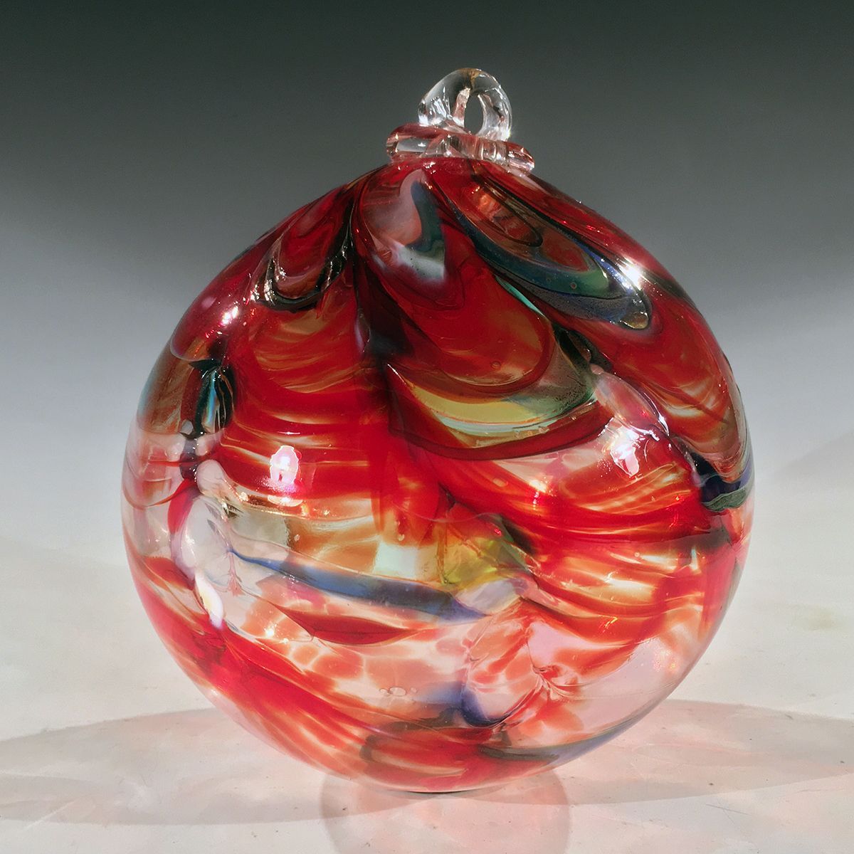 A red glass ornament is sitting on a table