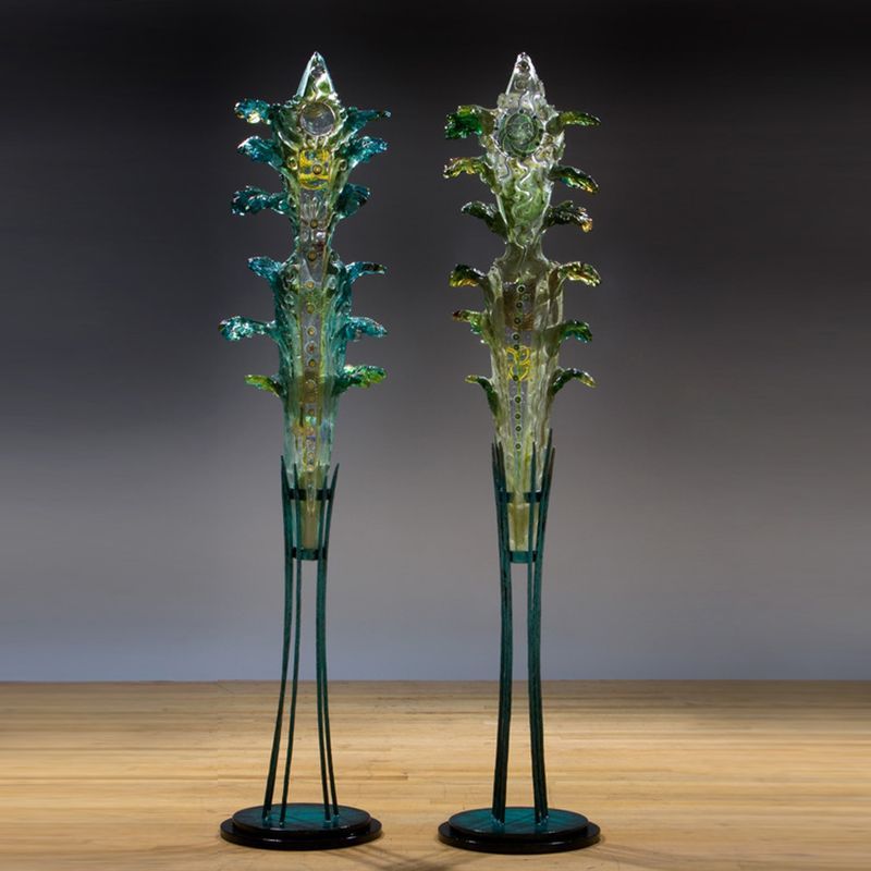 Two glass sculptures are sitting on a wooden table