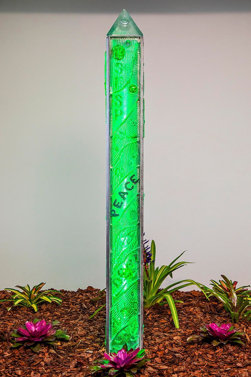 A green pole with the word peace written on it