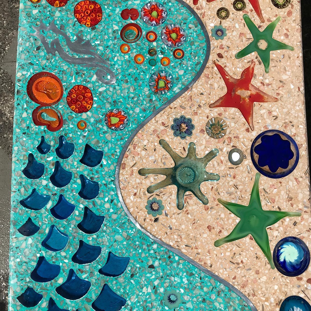 A mosaic of seashells and flowers on a table